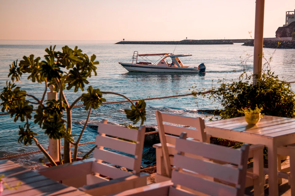 A boat on calm coastal water, seen from a seaside terrace in Dibba.